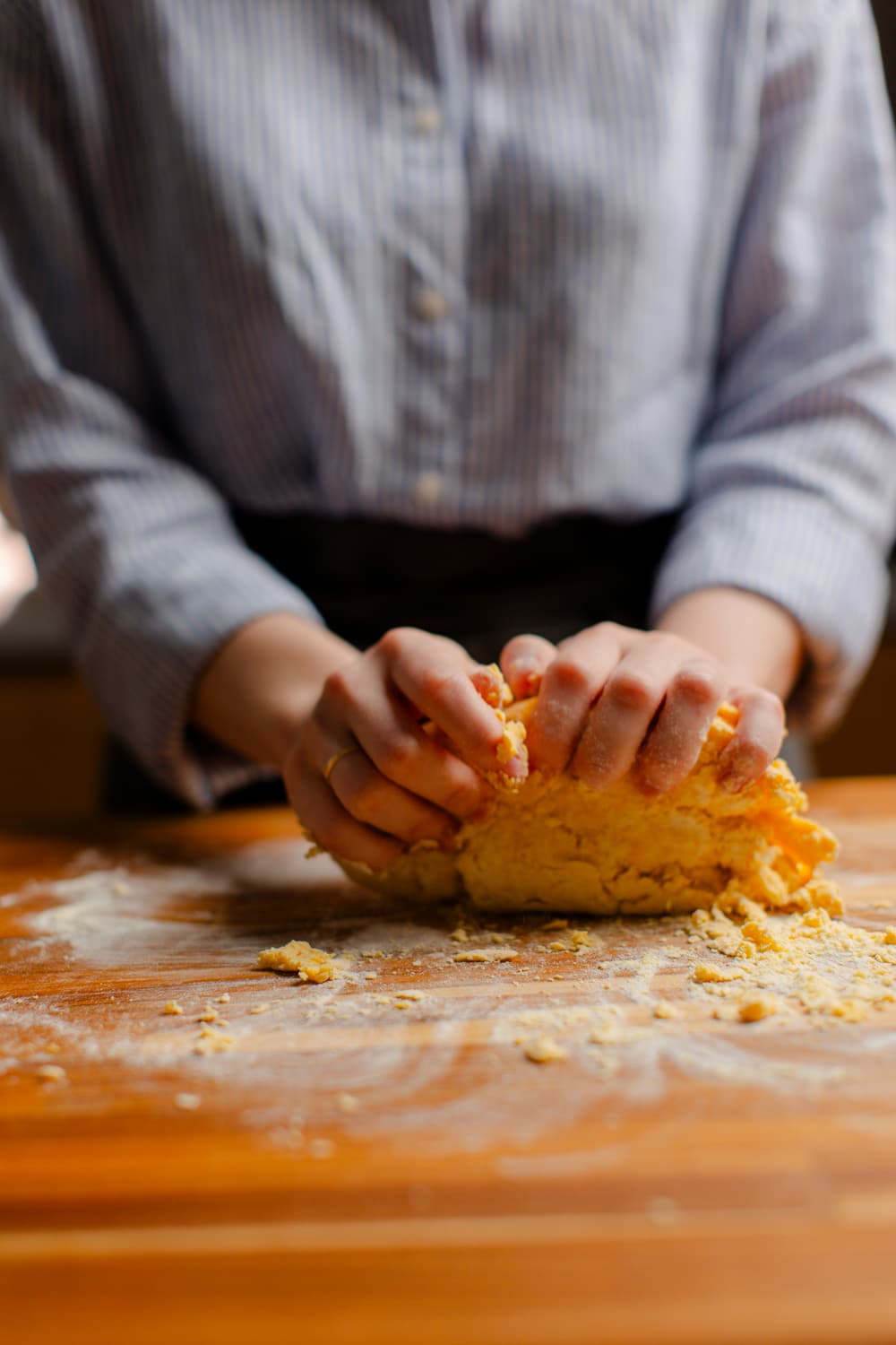 Alexia finalizando uma preparação empanada com as duas mãos